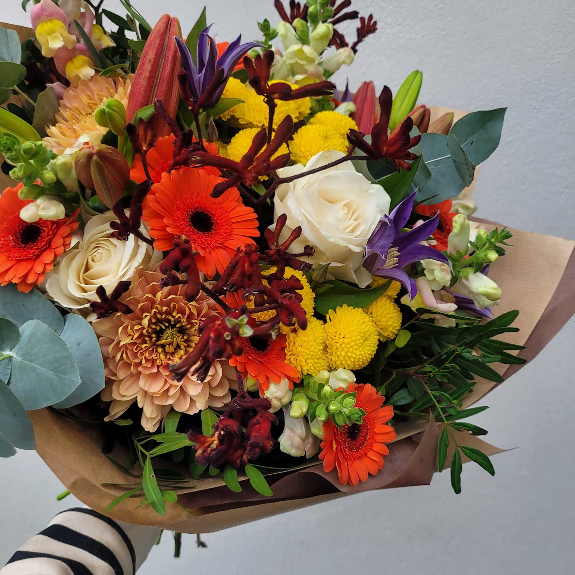 The "Florist Choice - Brights" bouquet by ReCreation Flowers features vibrant seasonal blooms, hand-wrapped in brown paper. Available for same-day delivery from your Leigh on Sea florist.