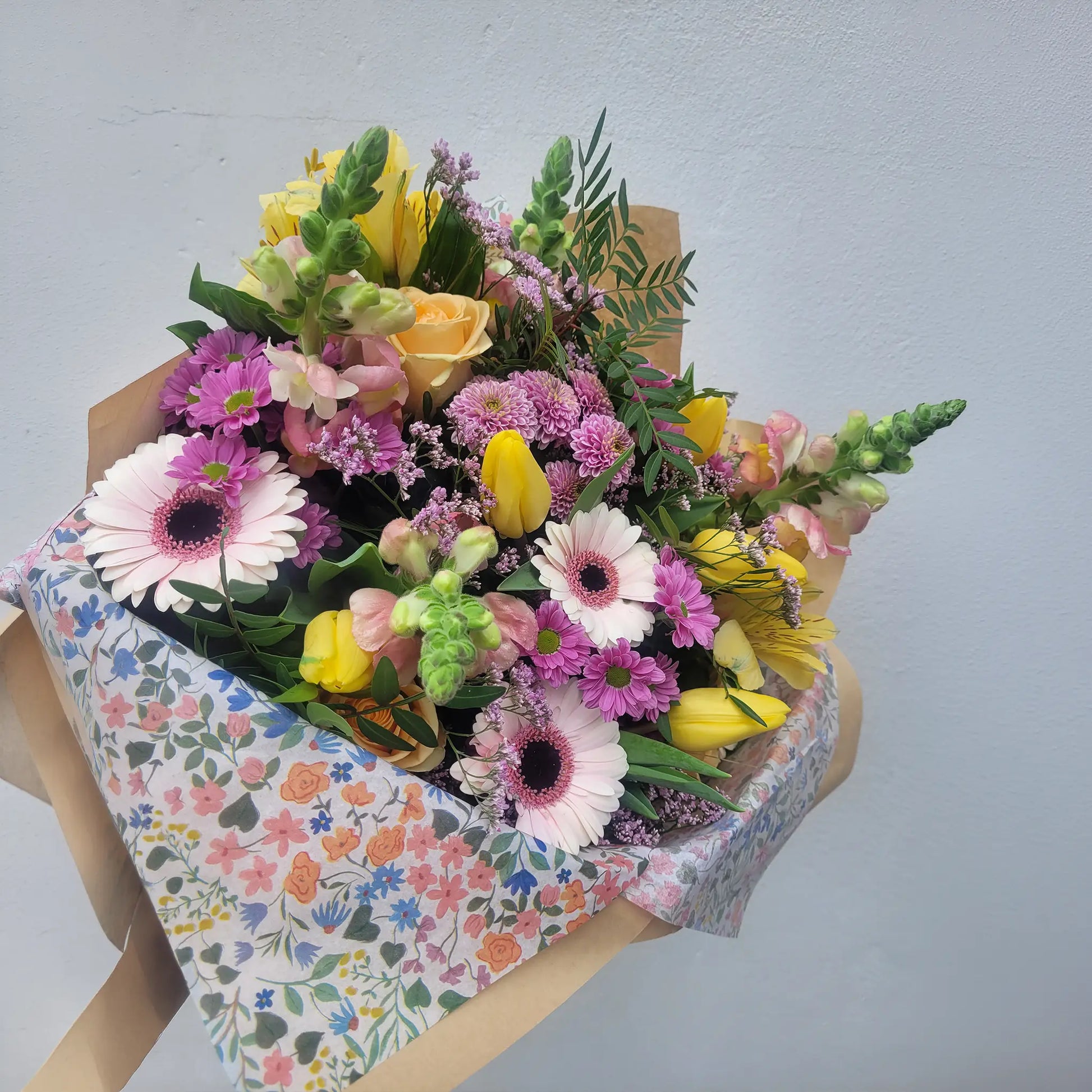 The "Florist Choice - Pastel" by ReCreation Flowers features pastel blooms and greenery, beautifully wrapped in brown paper with a floral sheet. Available for same-day delivery from your Leigh on Sea florist.