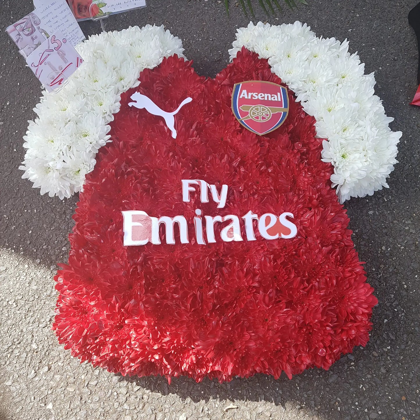 ReCreation Flowers’ Special Tributes offers a floral arrangement shaped like an Arsenal jersey, with red and white blooms, club logos, sponsor details, and background cards.
